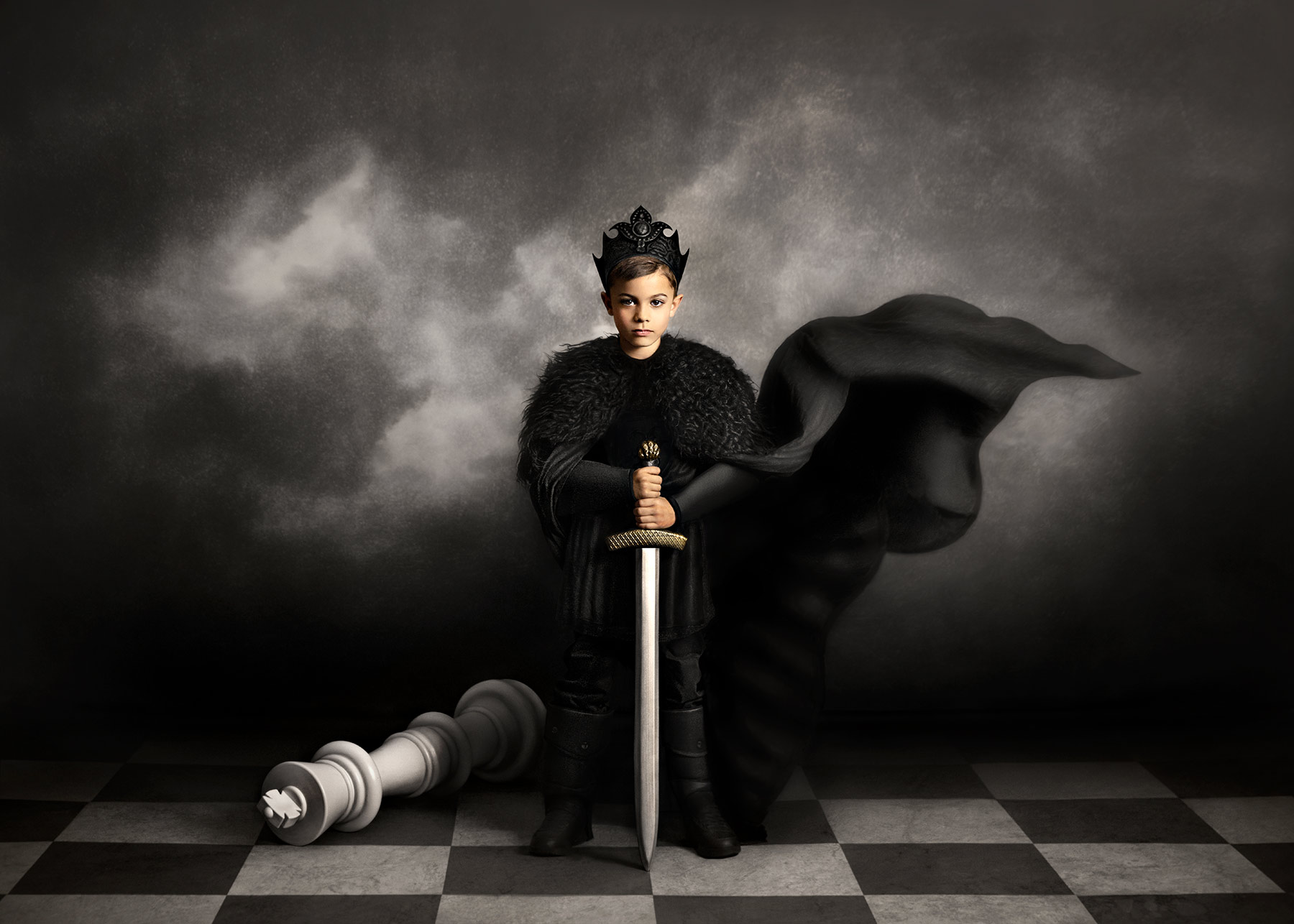 A child with a crown, lit creatively in a dark background